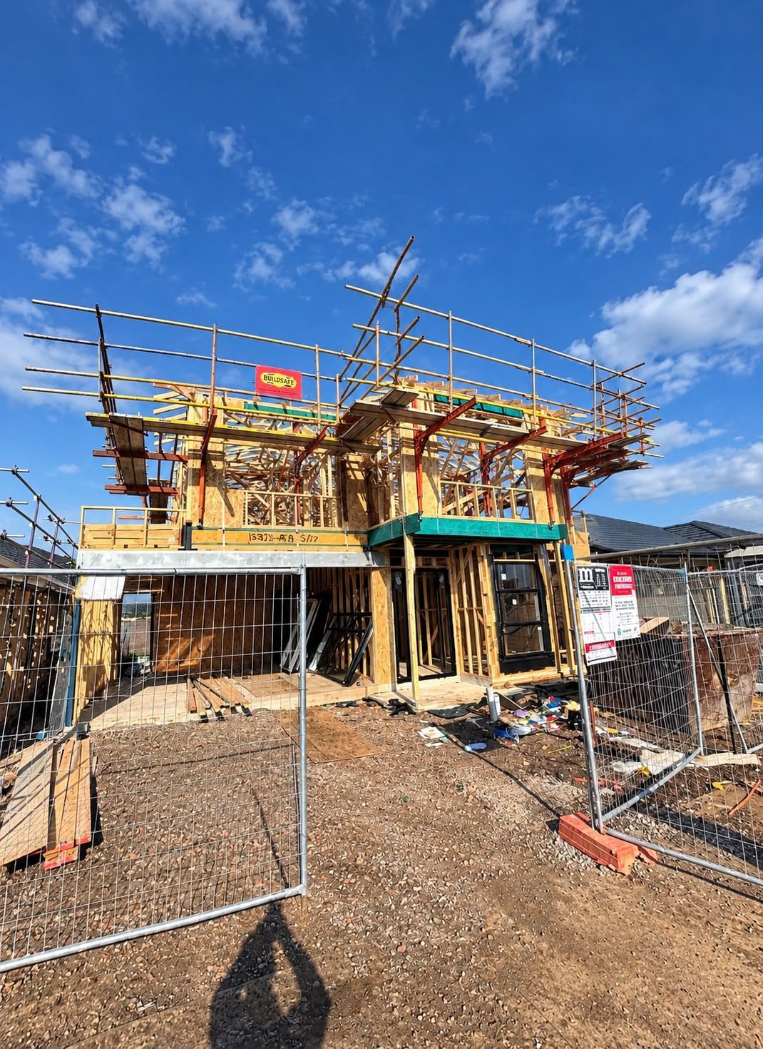 Double-storey house frame under scaffolding during timber framing works