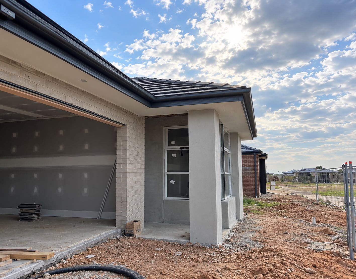 New home at lock-up stage with rendered portico columns and garage opening