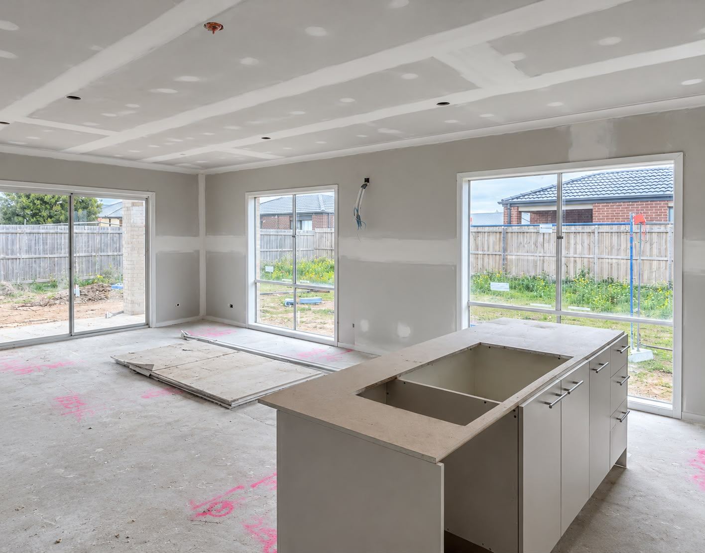 Open-plan kitchen and living area at fixing stage with island bench installed